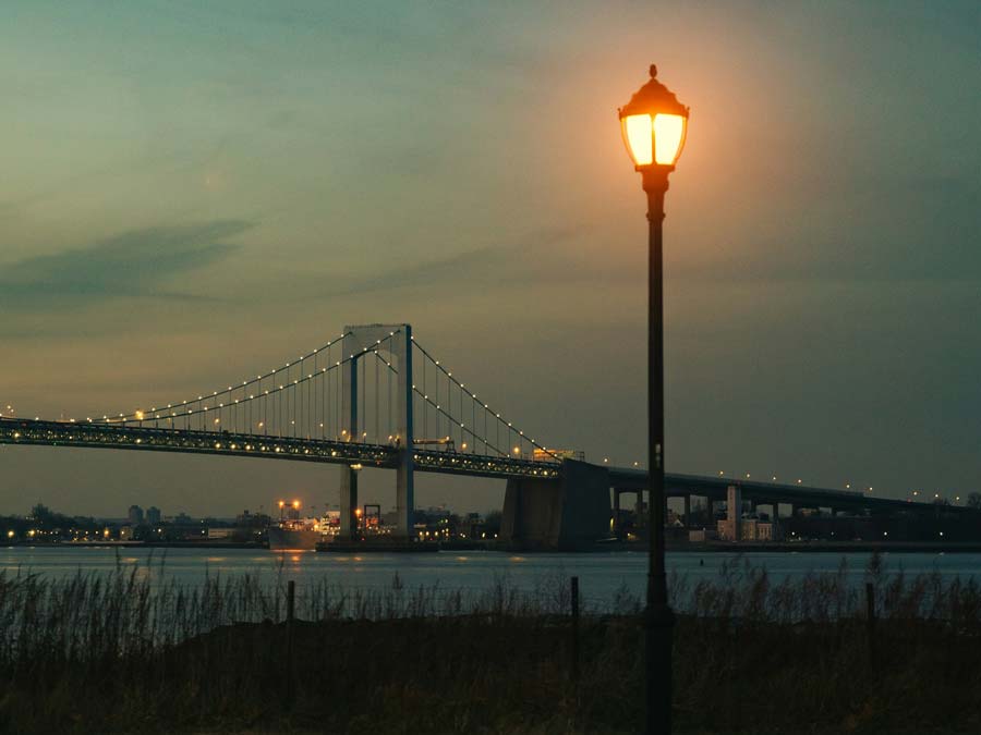 bridge over water and post-top light at dusk